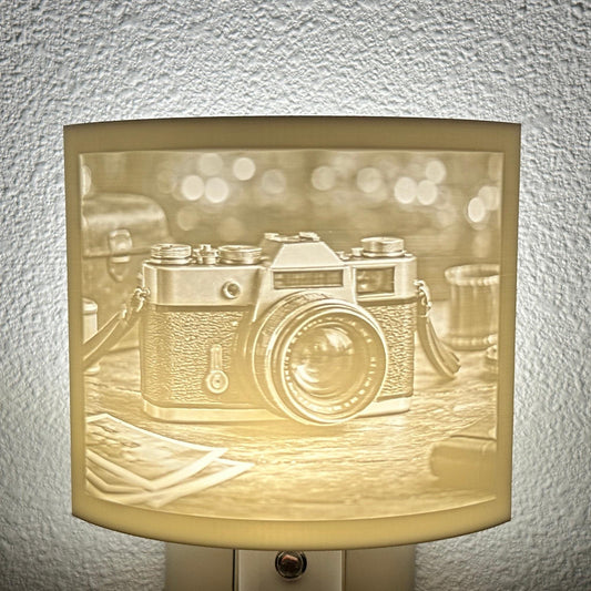 White camera lithophane night light featuring a detailed vintage-style camera on a tabletop with soft background lights, curved photography-themed decor for bedrooms, offices, studios, or camera enthusiasts.
