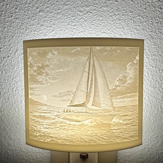 White sailboat lithophane night light with a softly glowing ocean scene, detailed sailboat, rolling waves, and cloudy sky, ideal for nautical, coastal, or beach house decor.