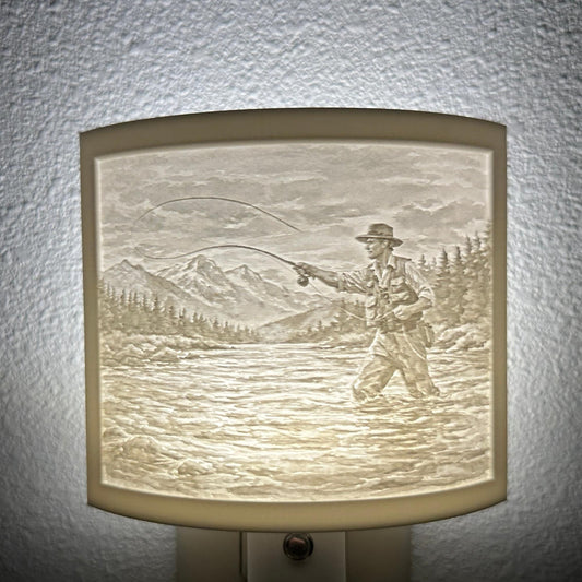 White fishing lithophane night light featuring a fly fisherman casting in a mountain river with forest and mountain scenery, softly glowing curved outdoor-themed decor for cabins, lodges, fishing enthusiasts, or rustic spaces.