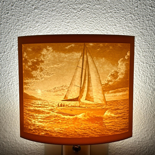 Warm glowing sailboat lithophane night light with detailed ocean waves and dramatic sunset sky, curved nautical lamp decor for coastal bedroom, hallway, or beach house ambiance.