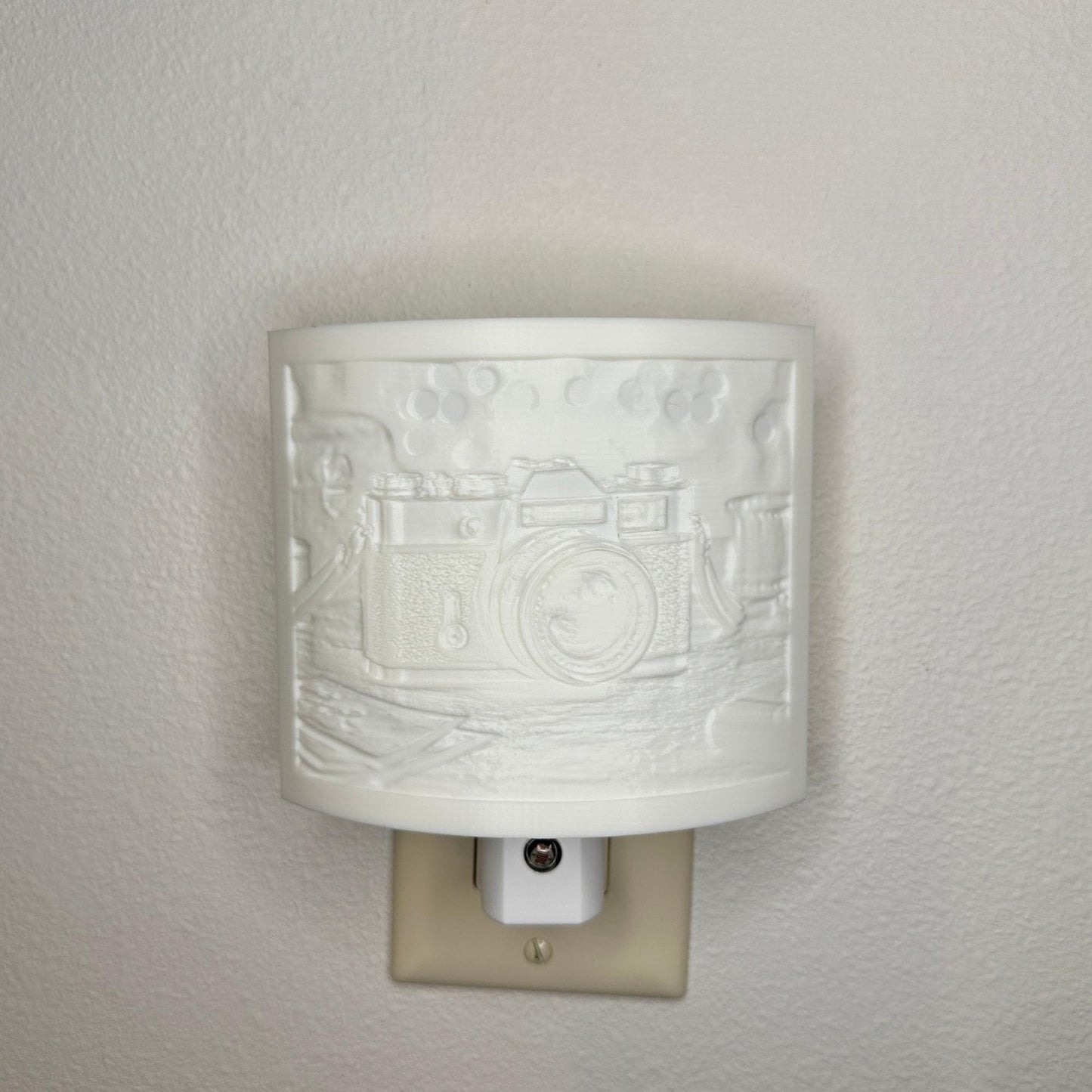 White camera lithophane night light with embossed vintage-style camera design on a tabletop scene, curved photography-themed decor for bedrooms, offices, studios, or camera enthusiasts.