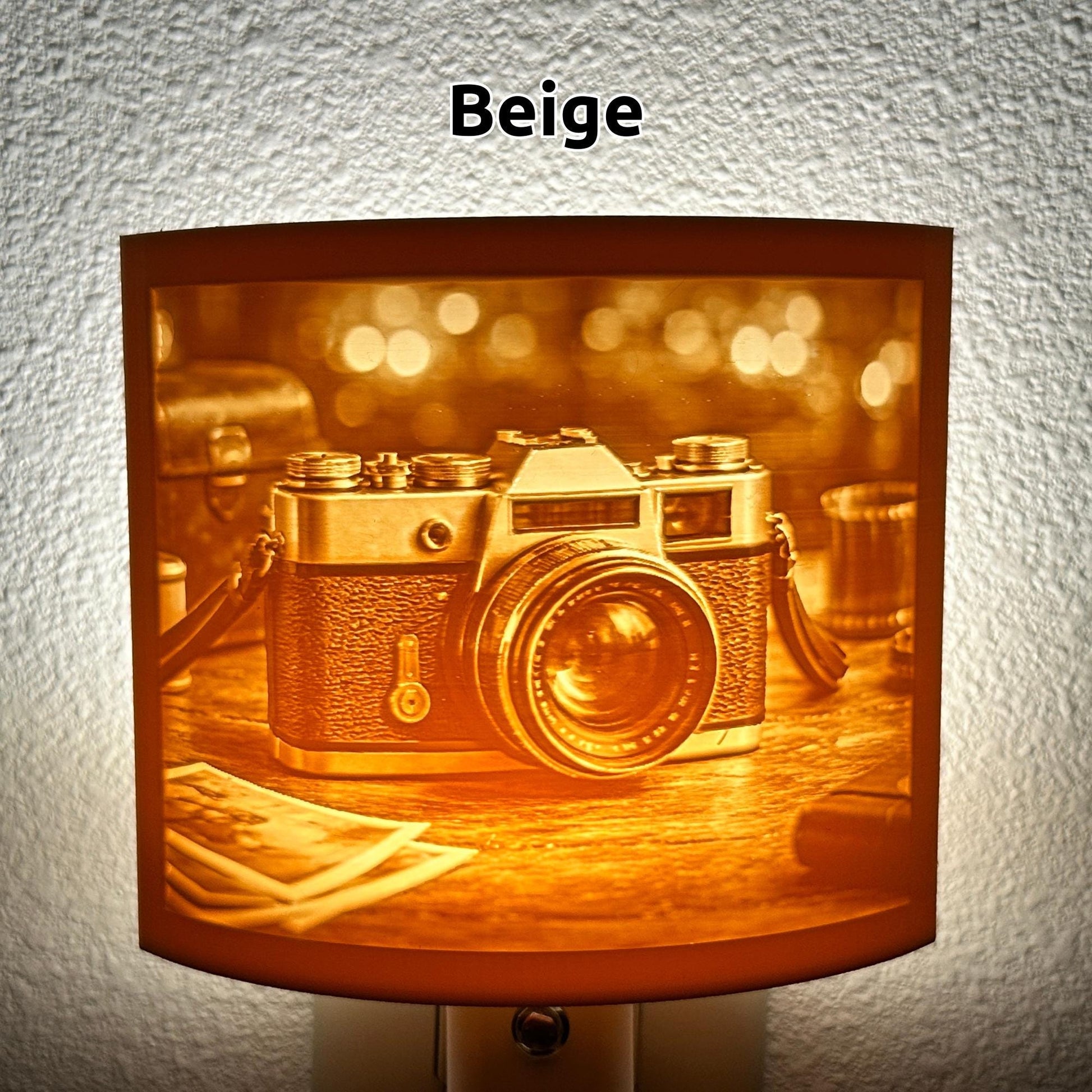 Warm glowing camera lithophane night light featuring a detailed vintage-style camera on a tabletop with blurred background lights, curved photography-themed decor for bedrooms, offices, studios, or camera lovers.
