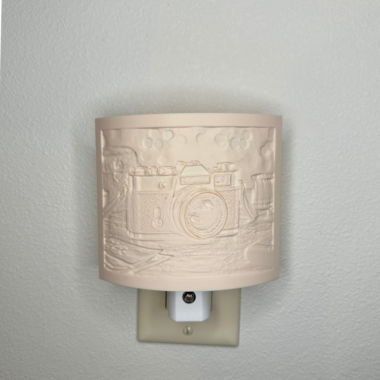 Beige camera lithophane night light with embossed vintage-style camera design on a tabletop scene, curved photography-themed decor for bedrooms, offices, studios, or camera enthusiasts.