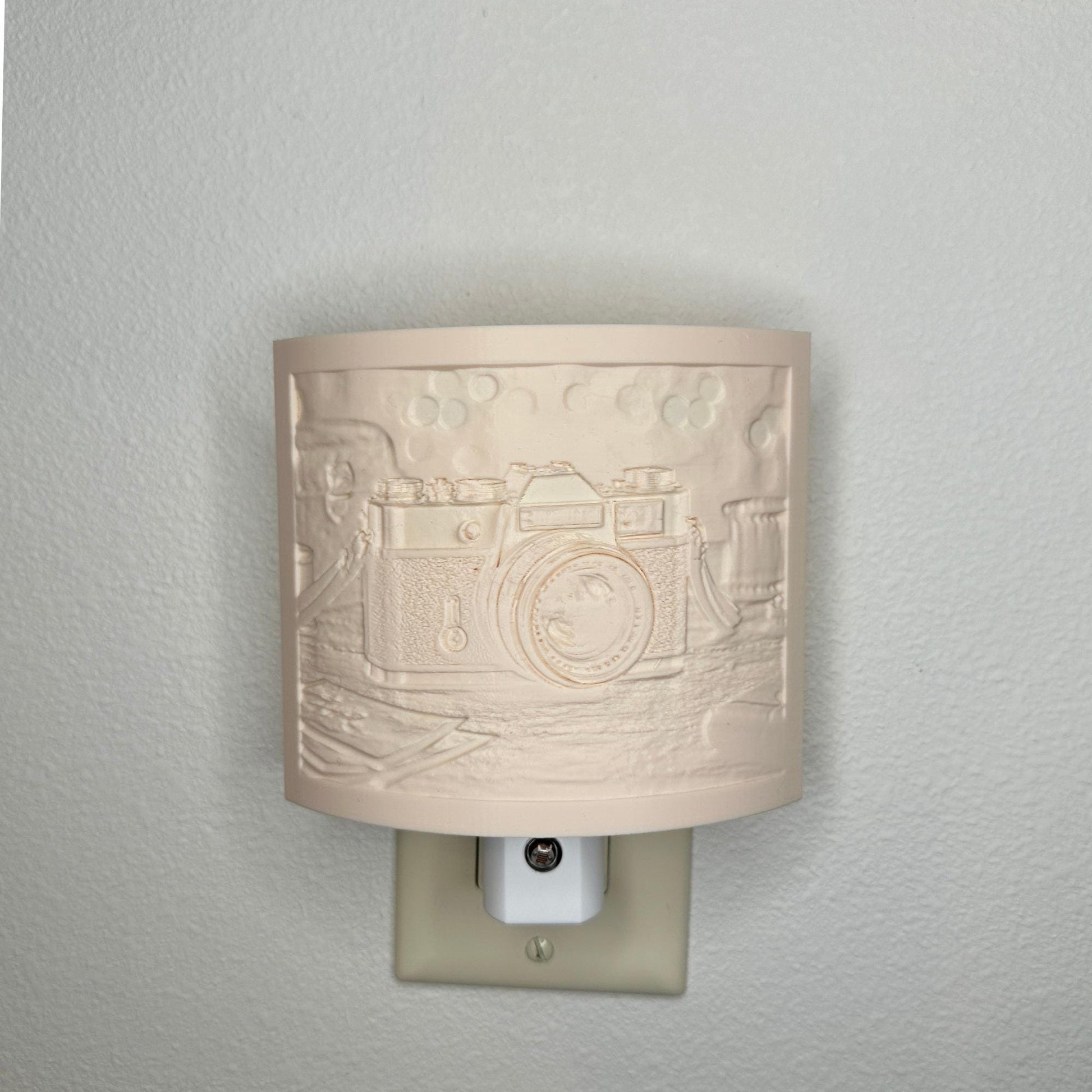Beige camera lithophane night light with embossed vintage-style camera design on a tabletop scene, curved photography-themed decor for bedrooms, offices, studios, or camera enthusiasts.