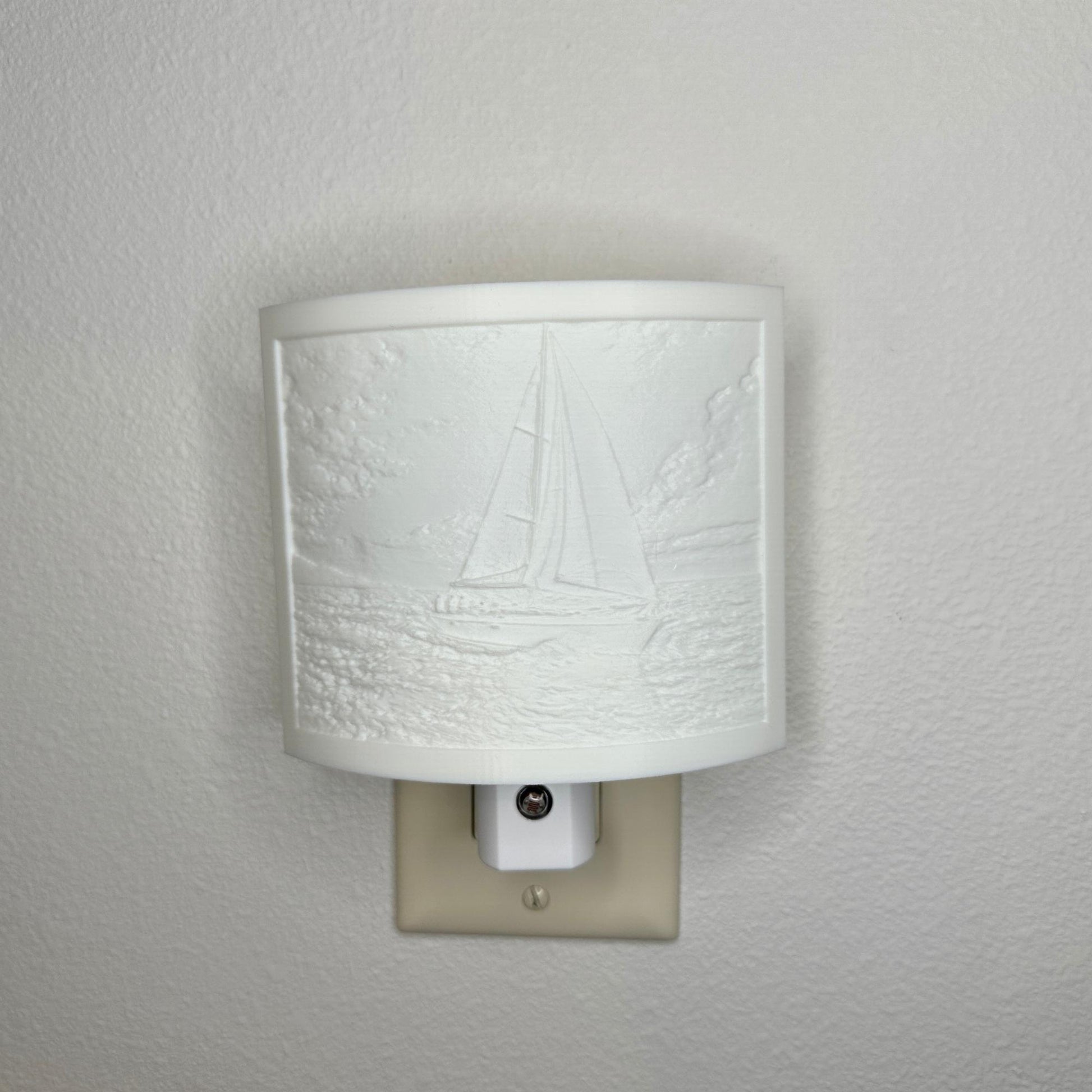 White sailboat lithophane night light with embossed sailing scene featuring ocean waves, clouds, and a detailed sailboat, curved nautical wall decor for coastal or beach-themed spaces.