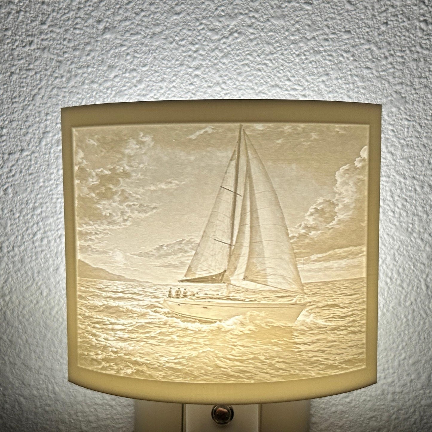 White sailboat lithophane night light with a softly glowing ocean scene, detailed sailboat, rolling waves, and cloudy sky, ideal for nautical, coastal, or beach house decor.