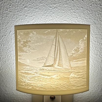 White sailboat lithophane night light with a softly glowing ocean scene, detailed sailboat, rolling waves, and cloudy sky, ideal for nautical, coastal, or beach house decor.
