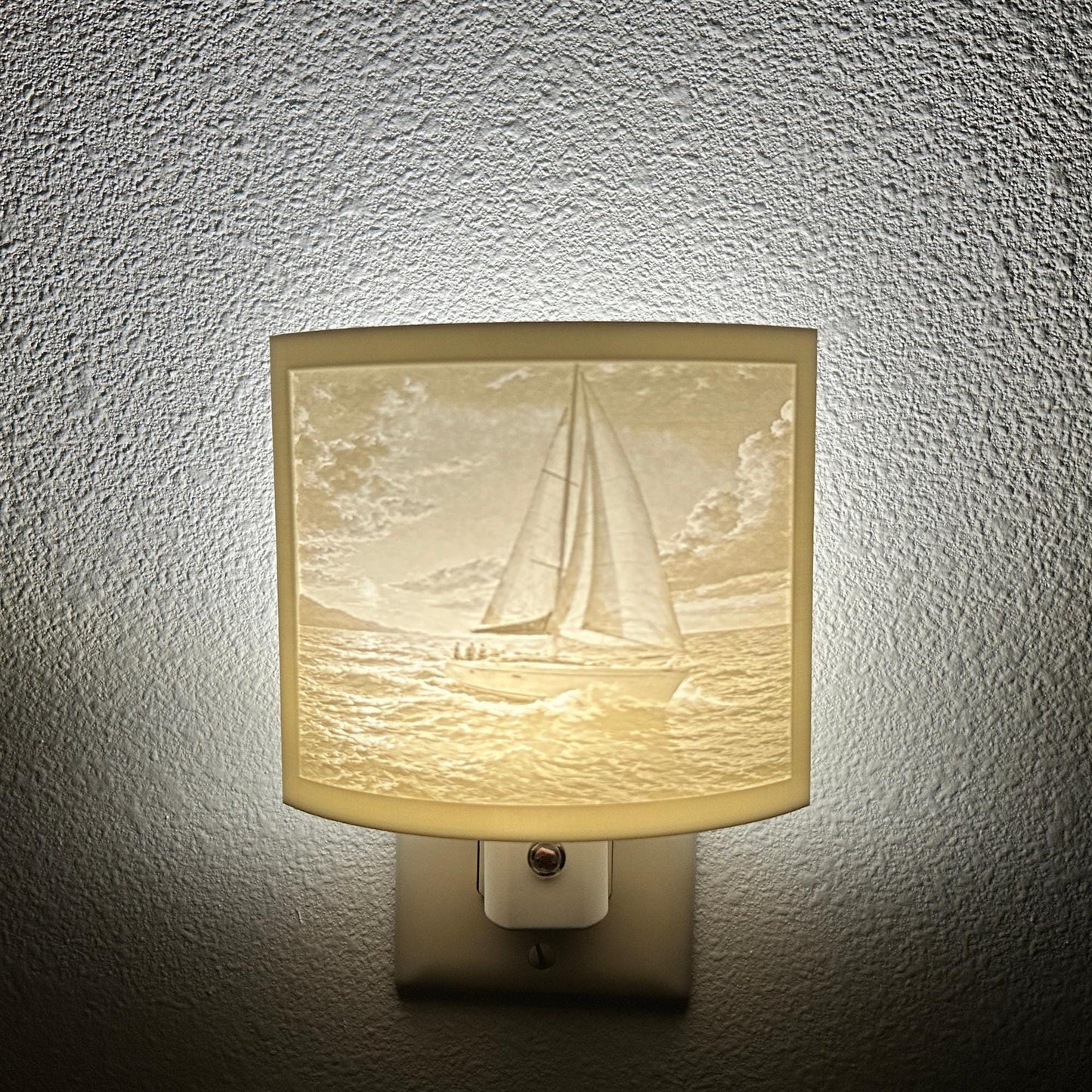 White sailboat lithophane night light with a softly glowing ocean scene, detailed sailboat, rolling waves, and cloudy sky, ideal for nautical, coastal, or beach house decor.
