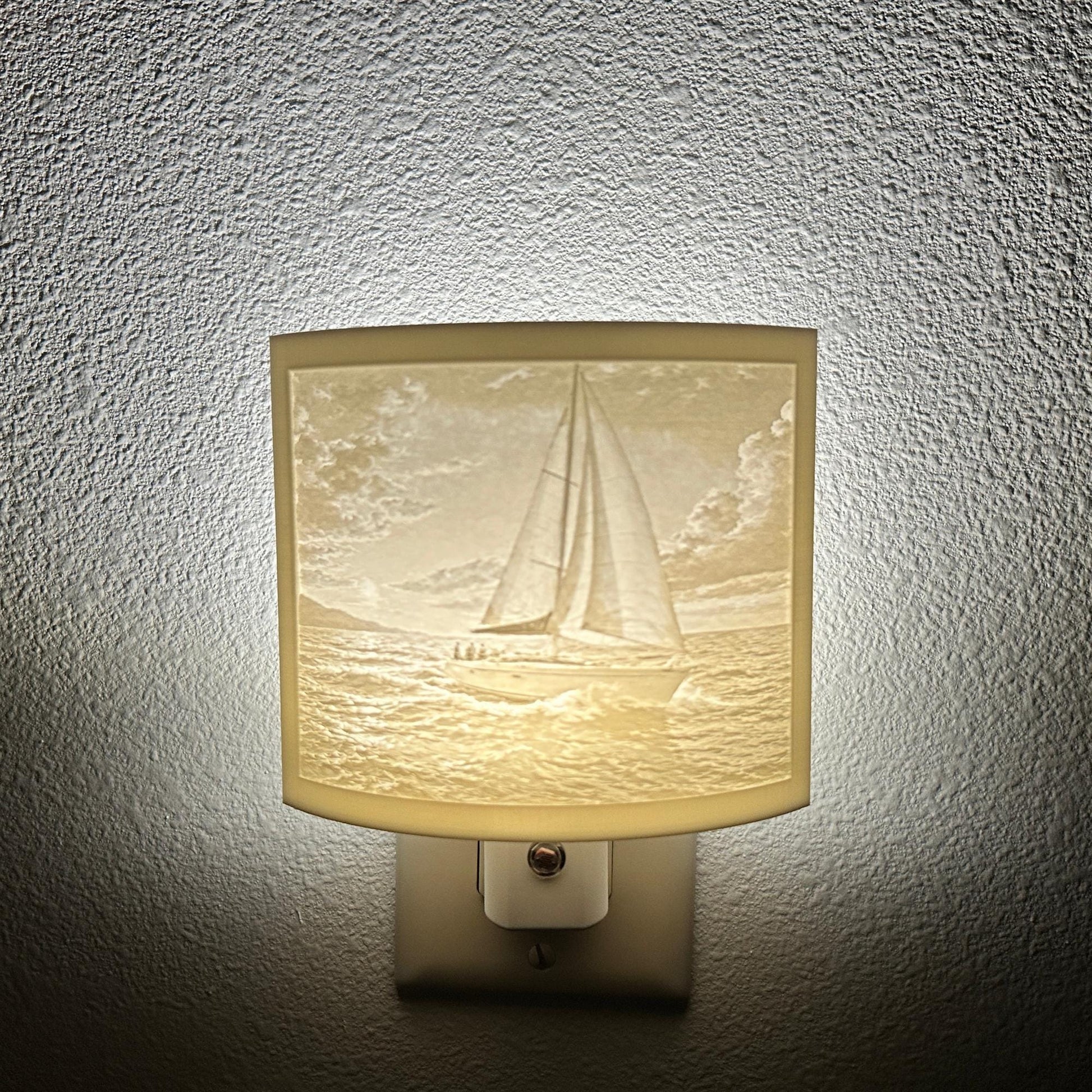 White sailboat lithophane night light with a softly glowing ocean scene, detailed sailboat, rolling waves, and cloudy sky, ideal for nautical, coastal, or beach house decor.