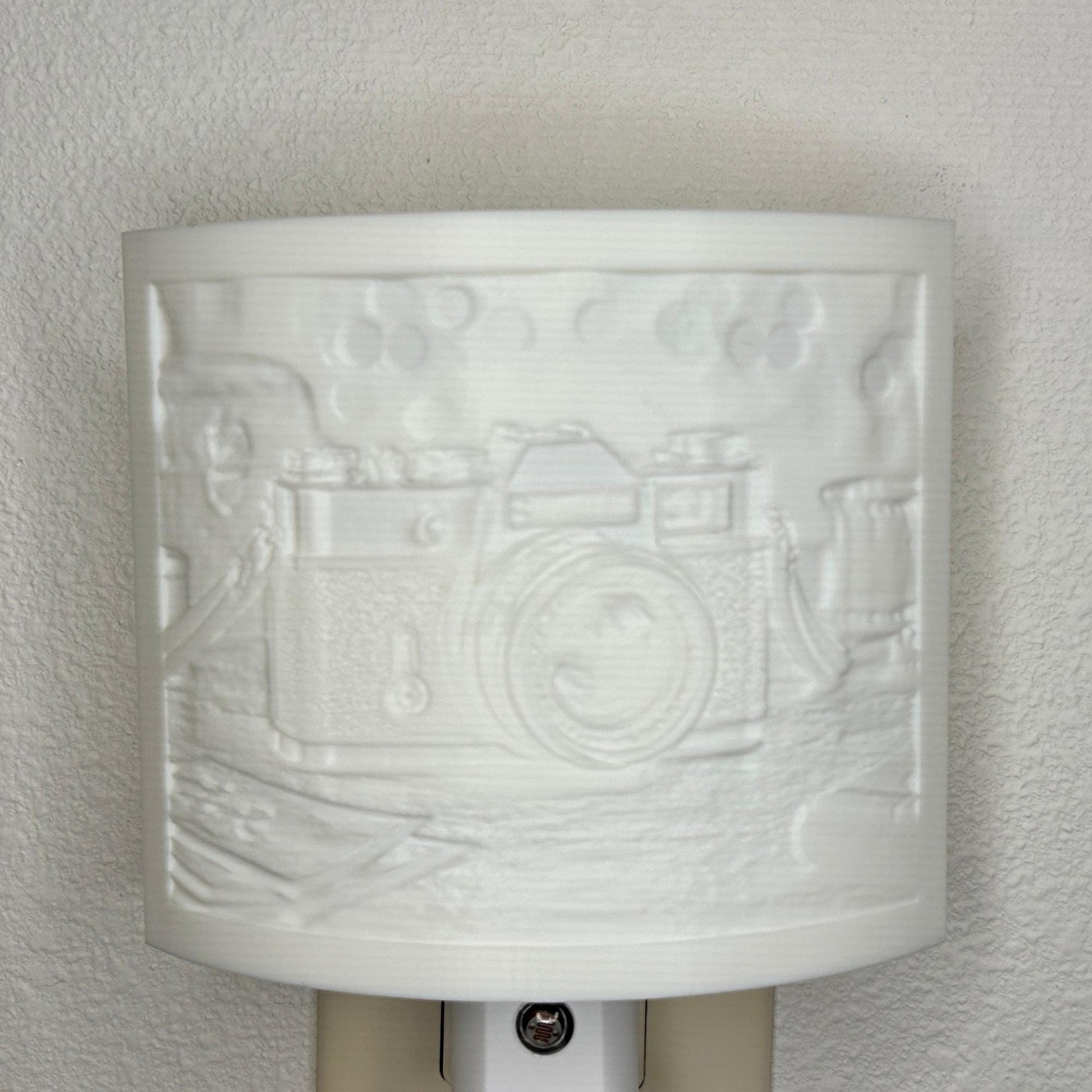 White camera lithophane night light with embossed vintage-style camera design on a tabletop scene, curved photography-themed decor for bedrooms, offices, studios, or camera enthusiasts.