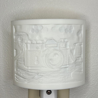 White camera lithophane night light with embossed vintage-style camera design on a tabletop scene, curved photography-themed decor for bedrooms, offices, studios, or camera enthusiasts.