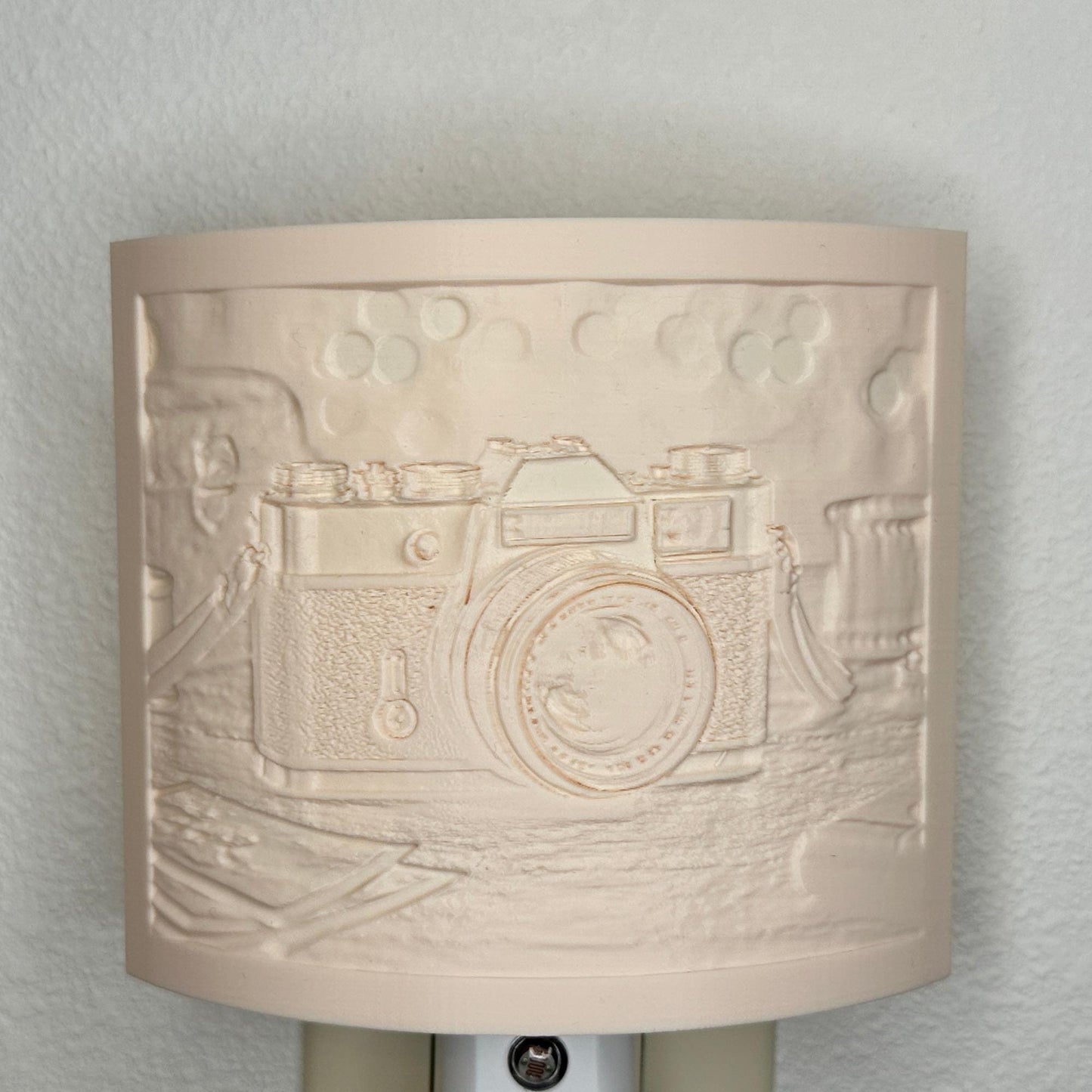 Beige camera lithophane night light with embossed vintage-style camera design on a tabletop scene, curved photography-themed decor for bedrooms, offices, studios, or camera enthusiasts.