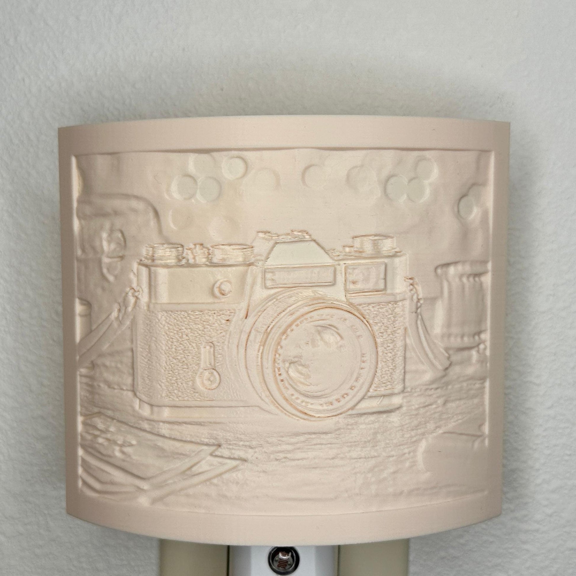 Beige camera lithophane night light with embossed vintage-style camera design on a tabletop scene, curved photography-themed decor for bedrooms, offices, studios, or camera enthusiasts.