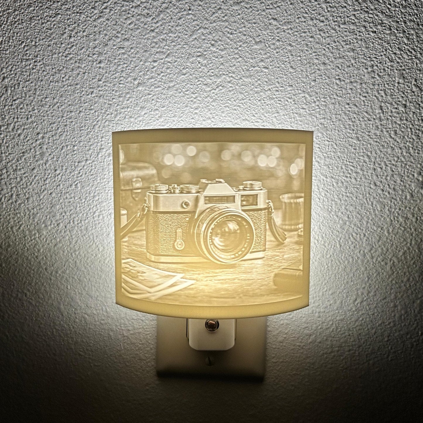 White camera lithophane night light featuring a detailed vintage-style camera on a tabletop with soft background lights, curved photography-themed decor for bedrooms, offices, studios, or camera enthusiasts.