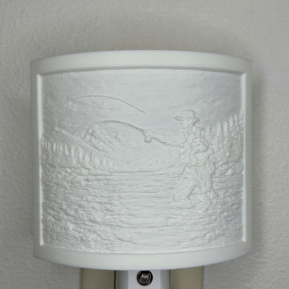 White fishing lithophane night light with embossed fly fisherman casting in a mountain river surrounded by forest and mountain scenery, curved outdoor-themed decor for cabins, lodges, fishing enthusiasts, or rustic spaces.