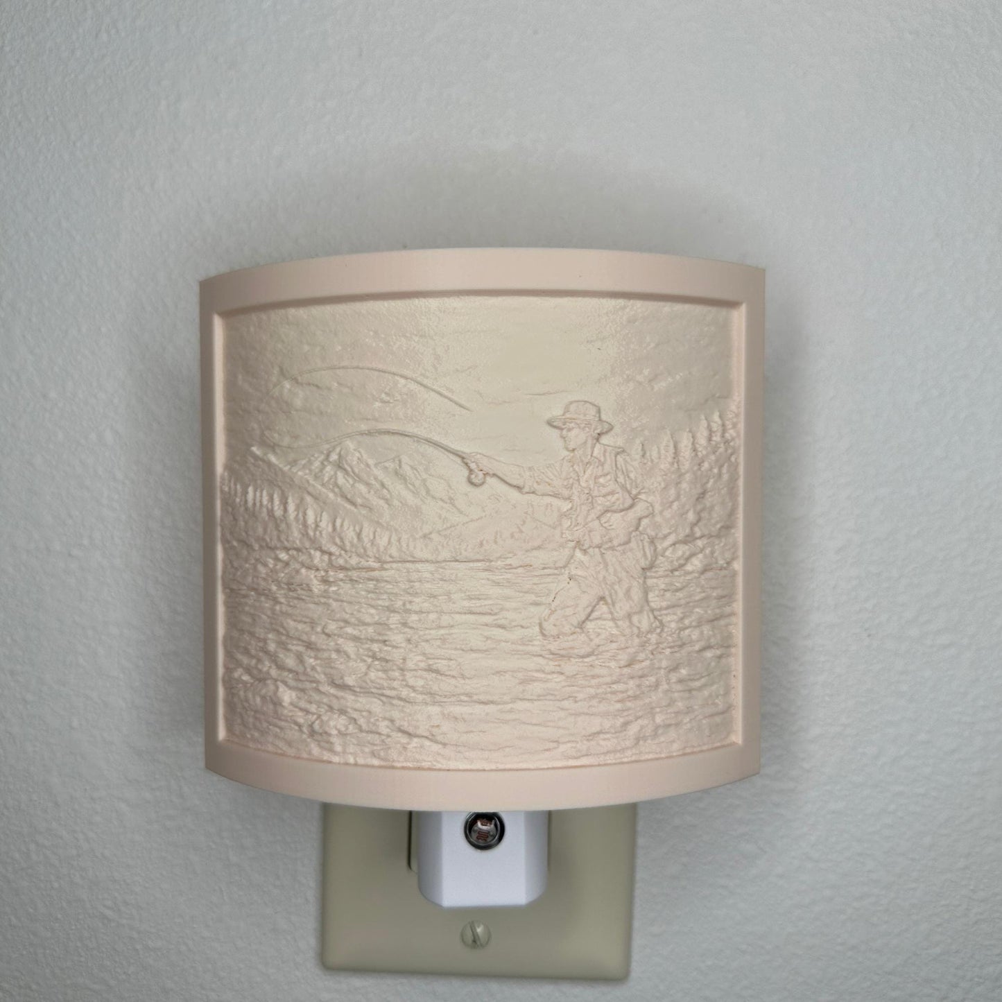 Beige fishing lithophane night light with embossed fly fisherman casting in a mountain river surrounded by forest and mountain scenery, curved outdoor-themed decor for cabins, lodges, fishing enthusiasts, or rustic spaces.