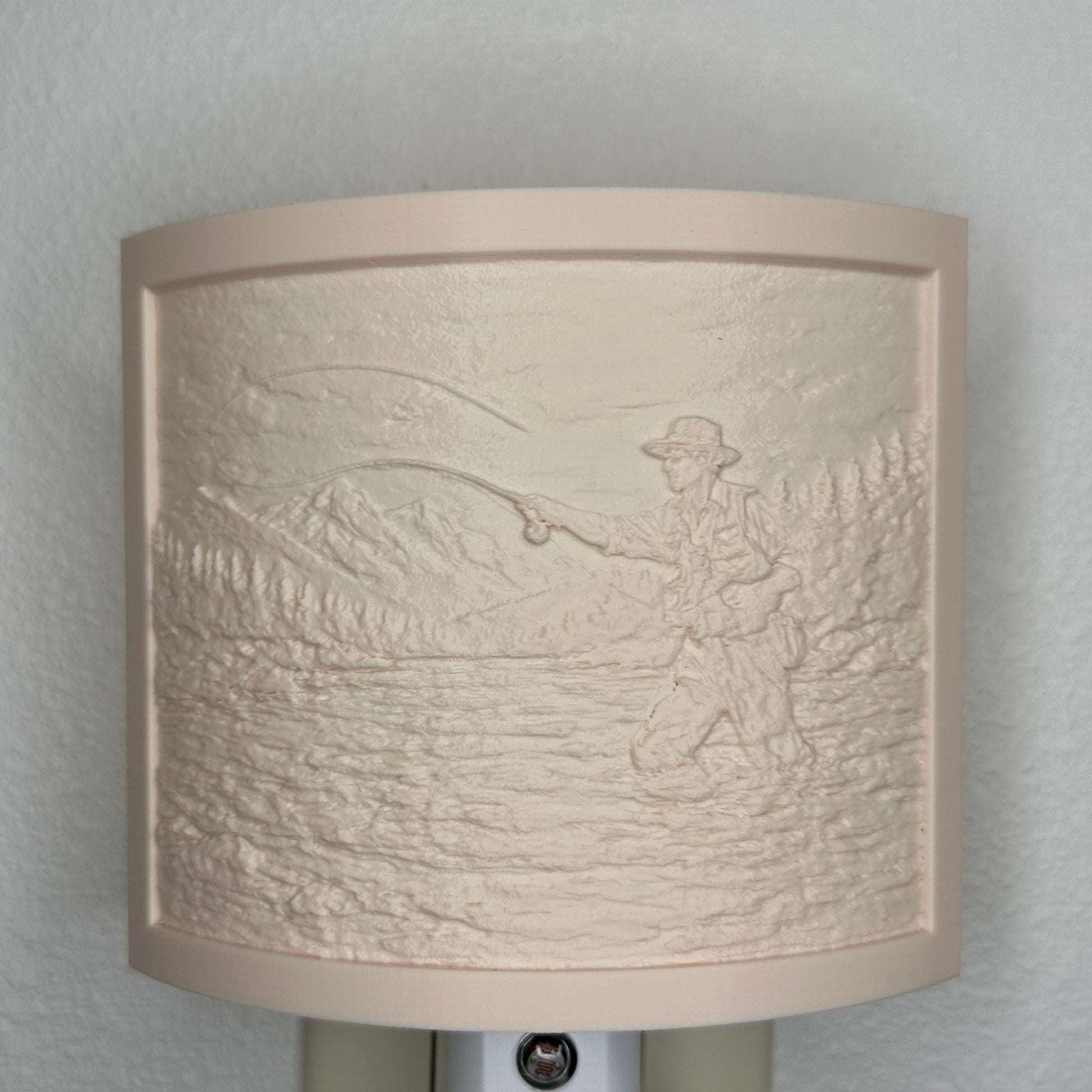 Beige fishing lithophane night light with embossed fly fisherman casting in a mountain river surrounded by forest and mountain scenery, curved outdoor-themed decor for cabins, lodges, fishing enthusiasts, or rustic spaces.