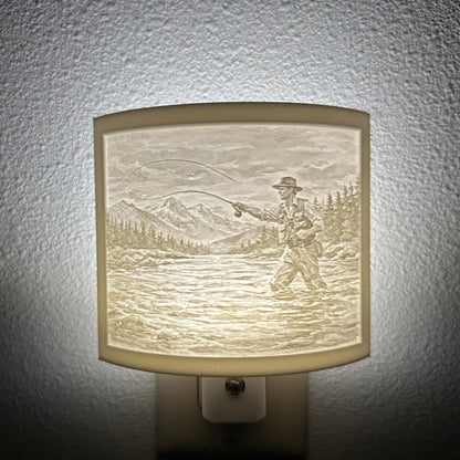 White fishing lithophane night light featuring a fly fisherman casting in a mountain river with forest and mountain scenery, softly glowing curved outdoor-themed decor for cabins, lodges, fishing enthusiasts, or rustic spaces.