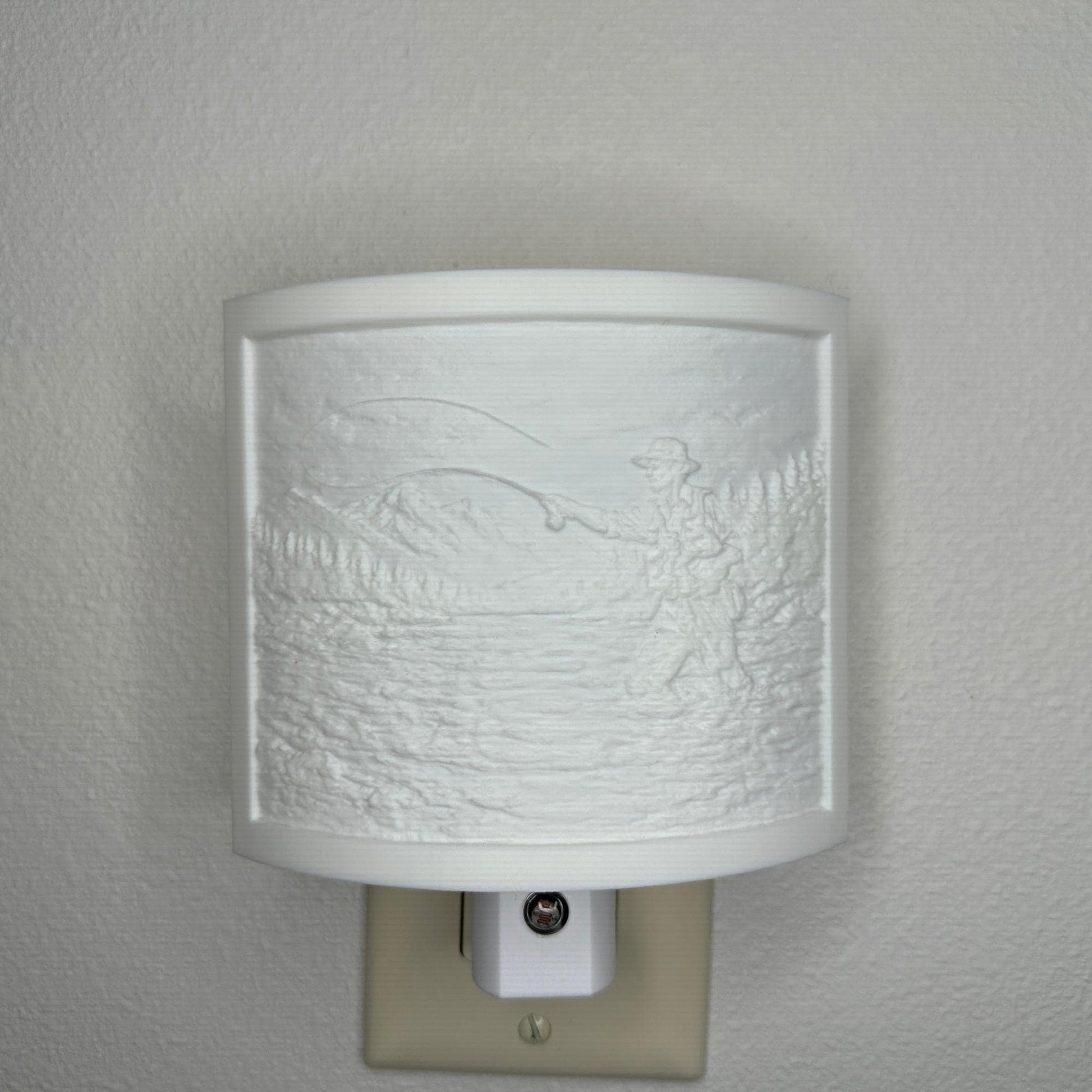 White fishing lithophane night light with embossed fly fisherman casting in a mountain river surrounded by forest and mountain scenery, curved outdoor-themed decor for cabins, lodges, fishing enthusiasts, or rustic spaces.